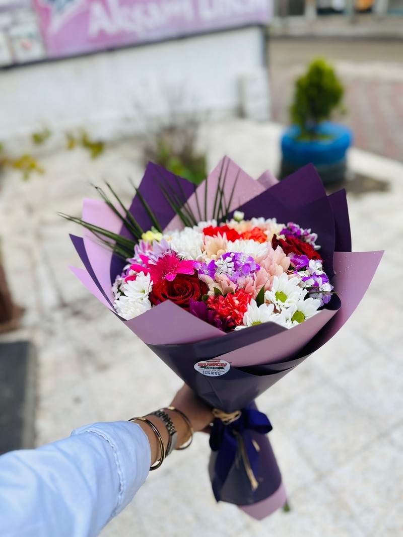 Mor ambalajda güller ve renkli çiçeklerle hazırlanmış buket
