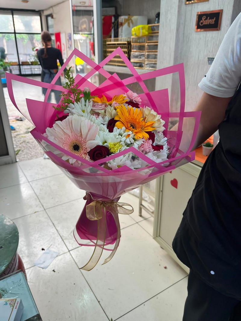 Pembe çerçeveli ambalaj içinde beyaz ve turuncu gerberalı papatya karışık buket